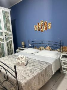 a blue bedroom with a bed with towels on it at Estía Holidays Apartments - Taormina in Taormina
