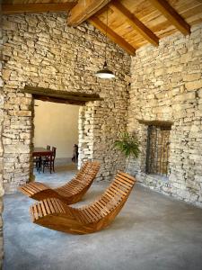 two chairs in a room with a stone wall at Agriturismo Cebon in Ceva