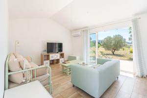 a living room with a couch and chairs and a window at Maison de campagne in Aubagne