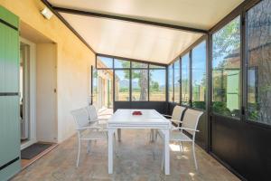 a dining room with a white table and chairs at Maison de campagne in Aubagne +20 photos