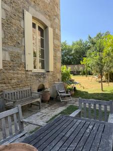 two benches and a table in front of a building at L Epernon in Alençon
