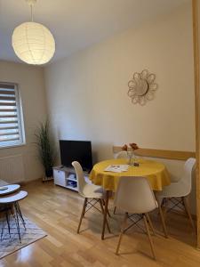 a dining room with a yellow table and chairs at Apartman Ninolić in Jagodina
