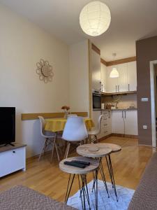 a living room with a table and chairs and a kitchen at Apartman Ninolić in Jagodina
