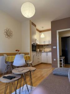 a kitchen and living room with a table and chairs at Apartman Ninolić in Jagodina +19 photos