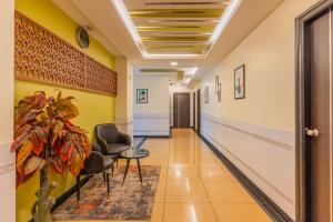a hallway in a hospital with chairs and a plant at Treebo Premium Raj Elegance Manyata Tech Park in Bangalore