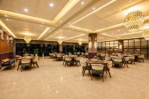a dining room with tables and chairs and chandeliers at Lotus Vista Hotel in Alwar