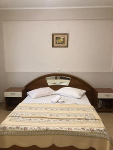 a bedroom with a bed with two nightstands and a framed picture at Villa Dream in Karianí
