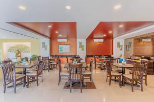 a dining room with tables and chairs in a restaurant at Treebo Premium Raj Elegance Manyata Tech Park in Bangalore