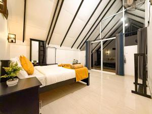 a bedroom with a large bed with yellow pillows at Tera Ella Boutique Hotel by SANS in Ella