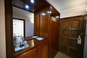a bathroom with a counter with a sink and a door at Aeroport Grand Hotel in Douala