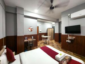 a hotel room with a bed and a flat screen tv at Hotel Pohor Regency 10 minutes travel to Kamakhya Temple in Guwahati