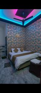 a bedroom with a large bed with a purple lighting at Hotel Vanilla inn in Bilāspur