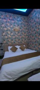a bedroom with a large bed with a floral wall at Hotel Vanilla inn in Bilāspur