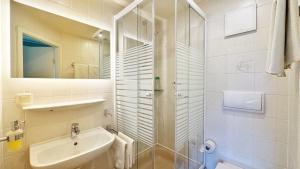 ein weißes Badezimmer mit Waschbecken und Dusche in der Unterkunft Hotel-Heilsberg in Gottmadingen + 26 Fotos