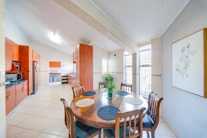 a kitchen and dining room with a wooden table and chairs at 22 on Nicol in Secunda