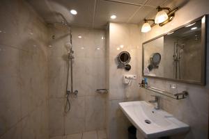a bathroom with a shower and a sink at Aeroport Grand Hotel in Douala