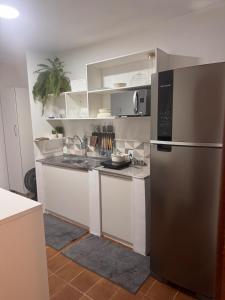 a kitchen with a stainless steel refrigerator and white cabinets at Office-Stay in Casimiro de Abreu