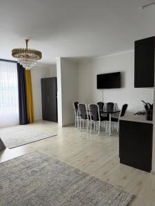 a living room with a dining table and chairs at Raduga West in Koshkolʼ