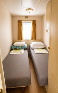 two beds in a small room with a window at Rowyhills in Rowy