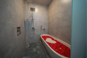 a bathroom with a bath tub covered in red flowers at Velonia Iseh in Sidemen +49 photos