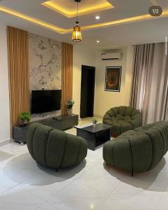 a living room with two chairs and a flat screen tv at Homelands in Port Harcourt