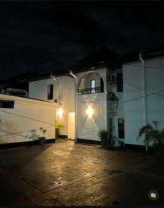 a large white building with a door at night at Homelands in Port Harcourt
