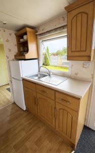 a kitchen with a sink and a refrigerator at Rowyhills in Rowy +10 photos