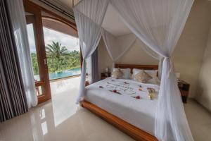 a bedroom with a bed with a canopy at Velonia Iseh in Sidemen