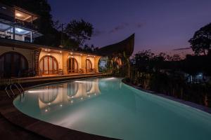 a swimming pool in front of a house at night at Velonia Iseh in Sidemen