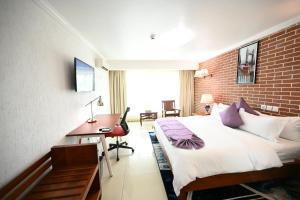 a hotel room with a bed and a desk at Aeroport Grand Hotel in Douala +26 photos