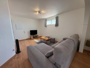a living room with a couch and a tv at The Arade Riverview in Portimão