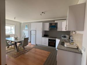 a kitchen with white cabinets and a table with chairs at The Arade Riverview in Portimão