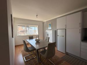 a dining room with a table and chairs and a refrigerator at The Arade Riverview in Portimão
