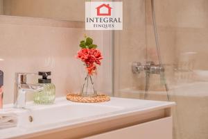 a vase of flowers sitting on a bathroom sink at Casa Norai in Palamós +22 photos