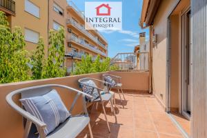 a balcony with chairs and tables on a building at Casa Norai in Palamós