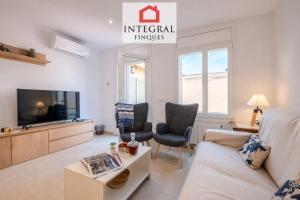a living room with a couch and a tv at Casa Norai in Palamós