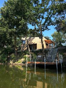 a cabin on the side of a lake with a dock at Glamping Hynkov in Příkazy
