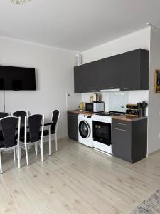 a kitchen with a stove and a dishwasher at Raduga West in Koshkolʼ