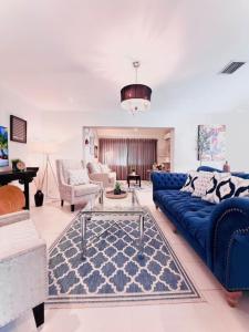 a living room with a blue couch and a table at The Miami Grove Oasis in Miami