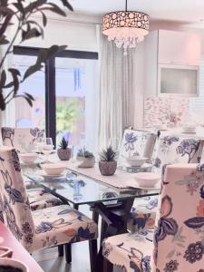 a dining room with a glass table and chairs at The Miami Grove Oasis in Miami