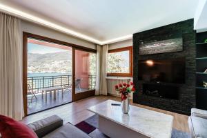 a living room with a fireplace and a tv at Il Sogno di Angelo - Blevio in Blevio