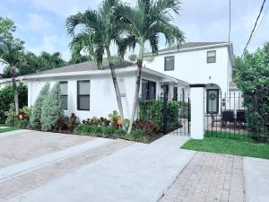 a white house with a palm tree in front of it at The Miami Grove Oasis in Miami