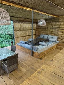 a bed on a wooden deck with a table at Отдых у речки in Almaty