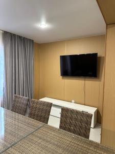 a room with a tv and a table and chairs at Отдых у речки in Almaty