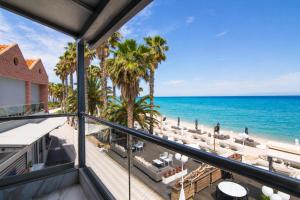 a view of the beach from the balcony of a resort at Tridente Mare Apart Hotel in Pefkochori