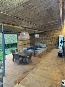 a patio with a couch and a table and chairs at Отдых у речки in Almaty