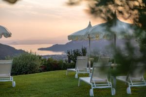 a group of chairs and a table with umbrellas at Hotel Boffenigo - The Golden Hour in Costermano +64 photos