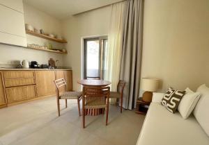 a living room with a table and chairs and a couch at MIRA MARE - Apartment 5 in Stavros