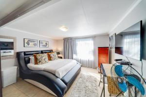 a bedroom with a bed and a desk in a room at 22 on Nicol in Secunda