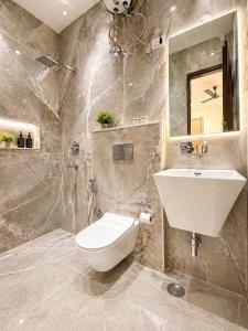 a bathroom with a white toilet and a sink at Hotel Grand Villa Suites Near Delhi International, IGI Airport in New Delhi +29 photos